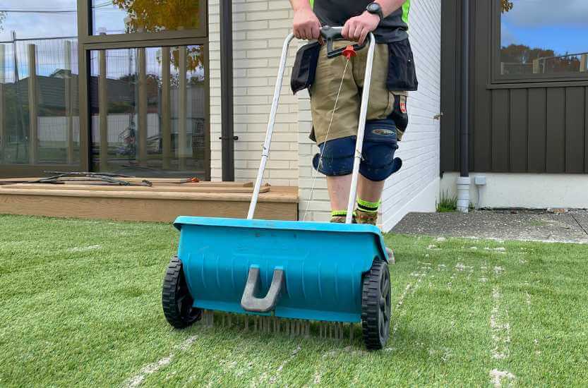 Residential project with silica sand infill being applied for artificial grass installation